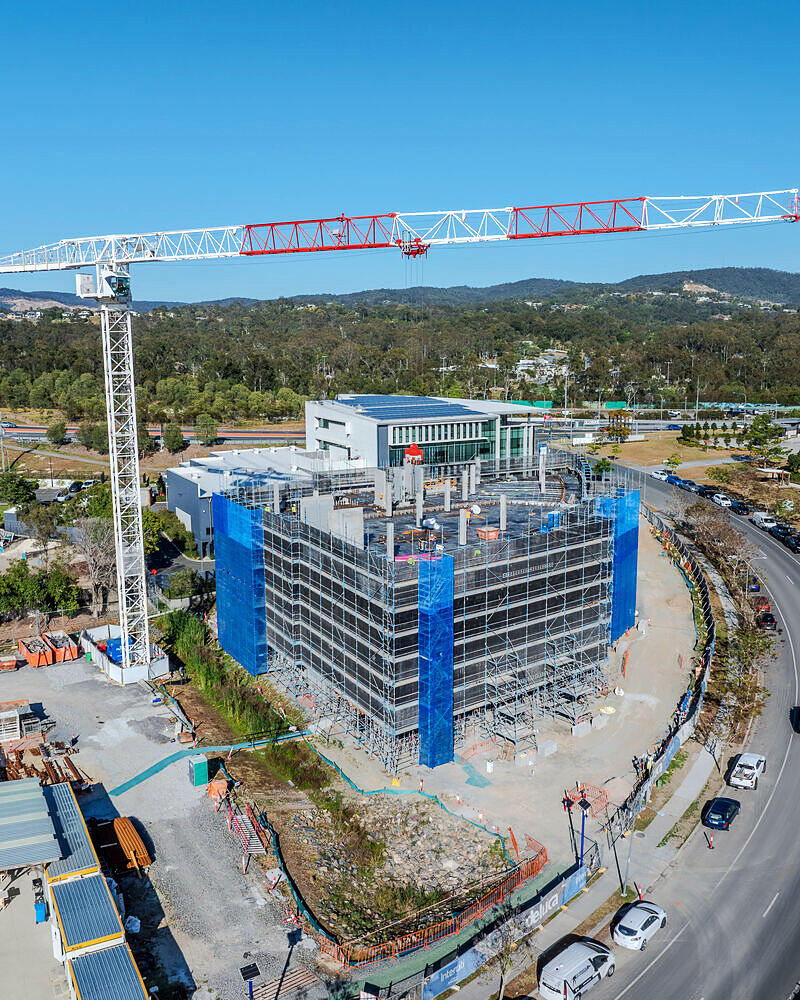 Drone progress photo of a building under construction with a tower crane at Ormeau, scaffolded by Elite Access Solutions