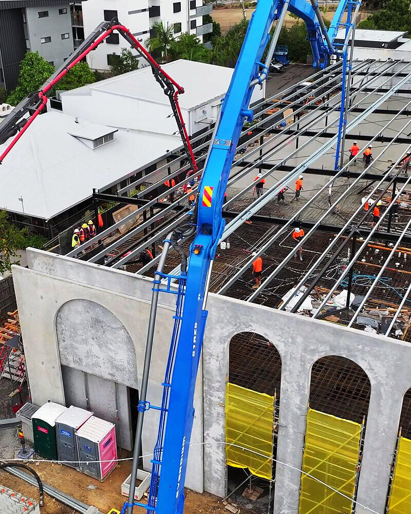 Drone shot of two boom pumps placing a suspended slab at Windsor for Black Fox Concrete Pumping